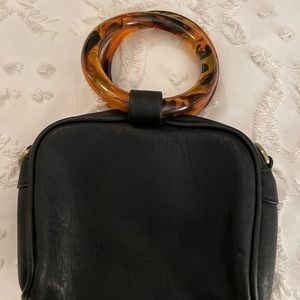 Black bag with tortoiseshell handle.